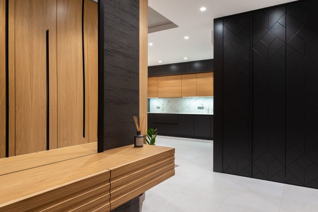 Modern bright house interior with cabinets and mirror in hall near entrance to kitchen